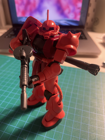 Char's Zaku Gunpla on a desk holding a machine gun